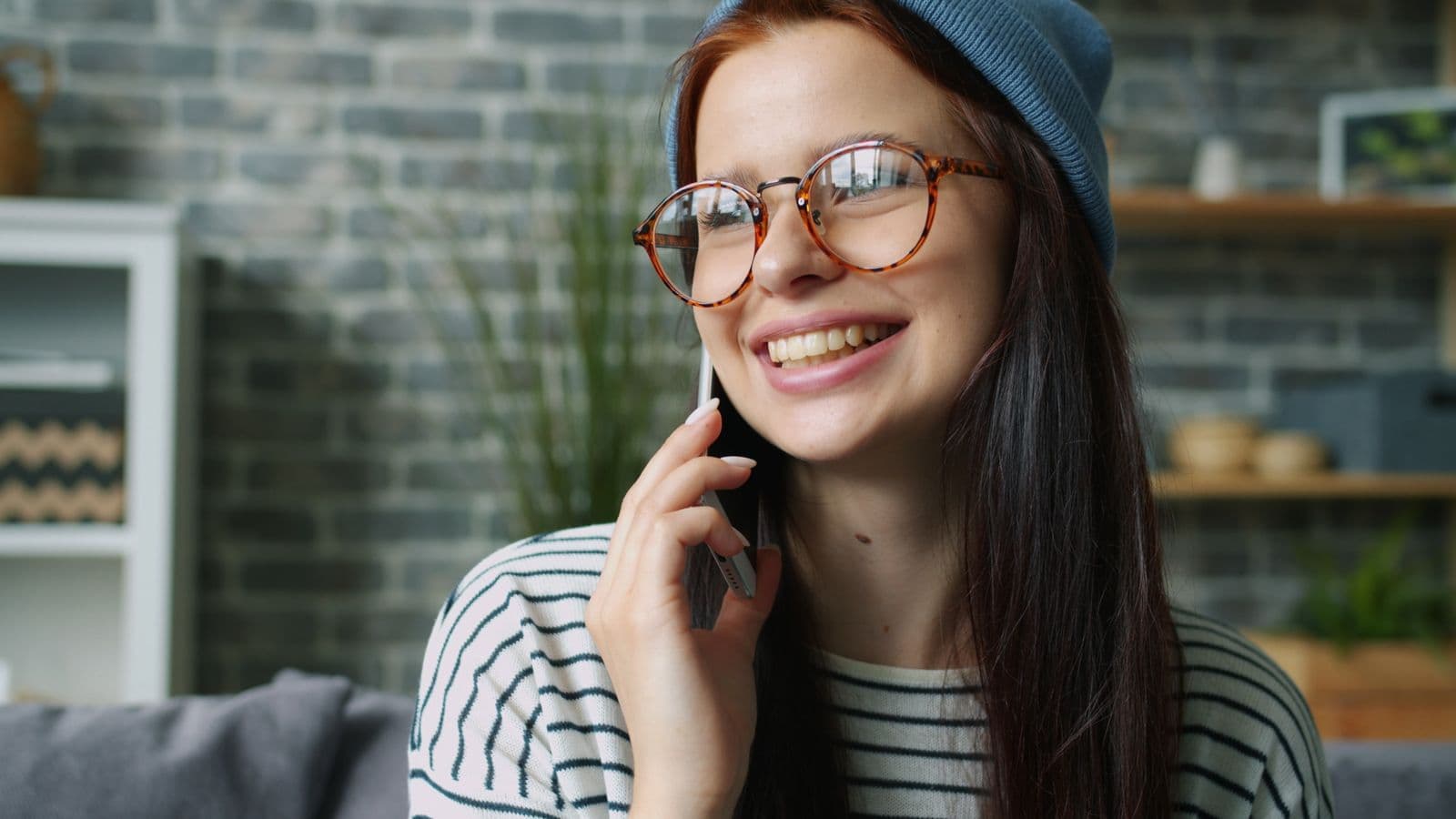 A woman smiling during a phone call at home